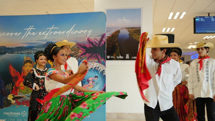 Ballet folclórico da la bienvenida a los turistas canadienses en la sala de llegadas del Aeropuerto de Zihuatanejo