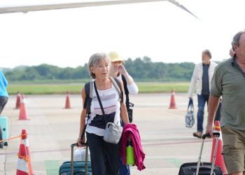 Turistas canadienses del vuelo inaugural de WestJet caminan por la pista del Aeropuerto Internacional de Zihuatanejo