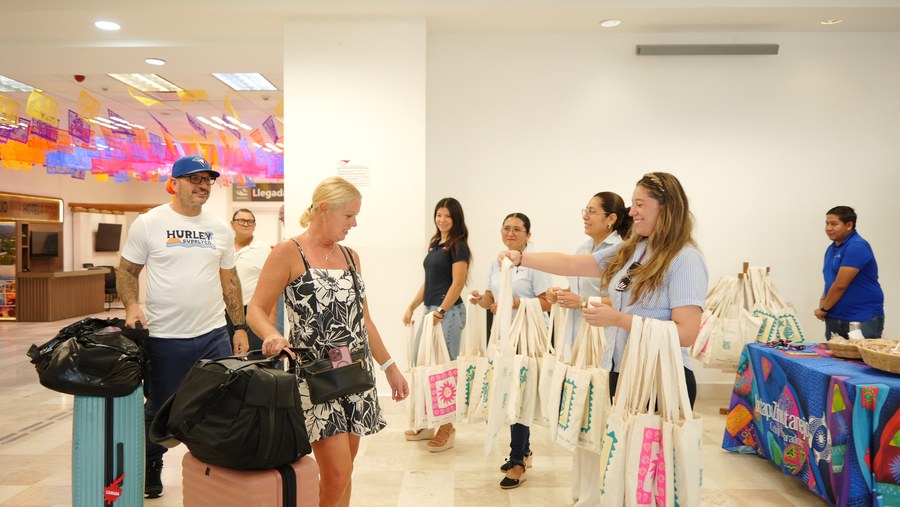 Entrega de bolsas de obsequios a los turistas del primer vuelo de la temporada invernal en Zihuatanejo