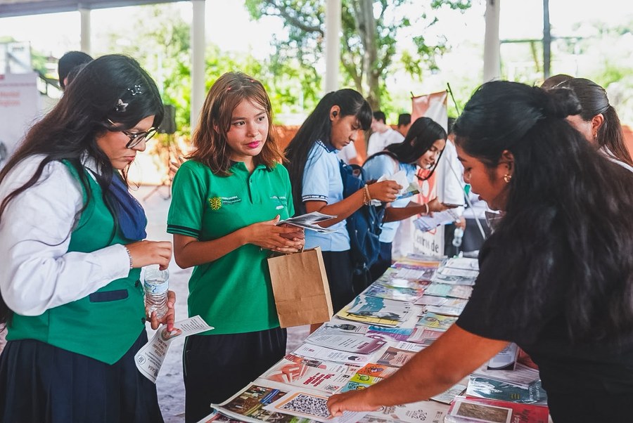 Estudiantes revisan folletos informativos en los módulos del encuentro sobre salud mental en Zihuatanejo